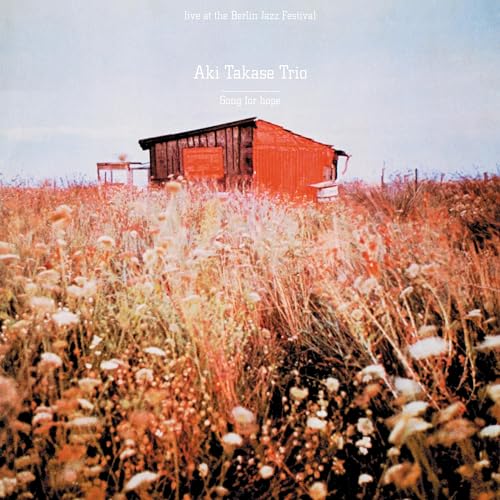 CD cover featuring a small red barn in a field of wildflowers.