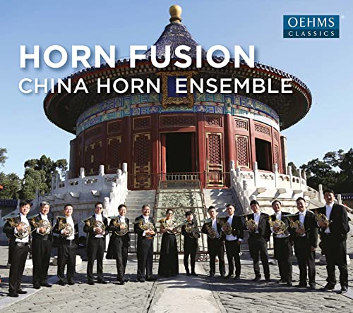 Horn players pose in front of a traditional Chinese building.
