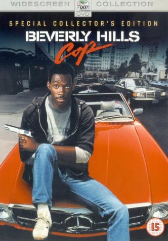Eddie Murphy with a gun, leaning on an orange convertible car.