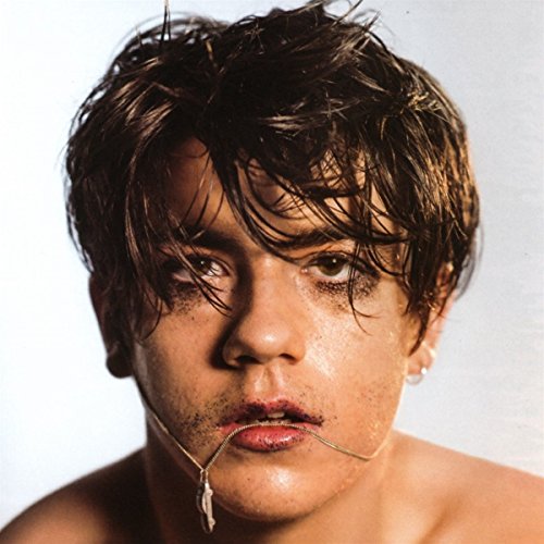Close-up portrait of Declan McKenna with smeared makeup and a necklace.