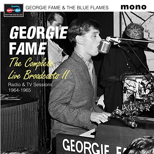 Georgie Fame performing into a microphone with band members in the background.