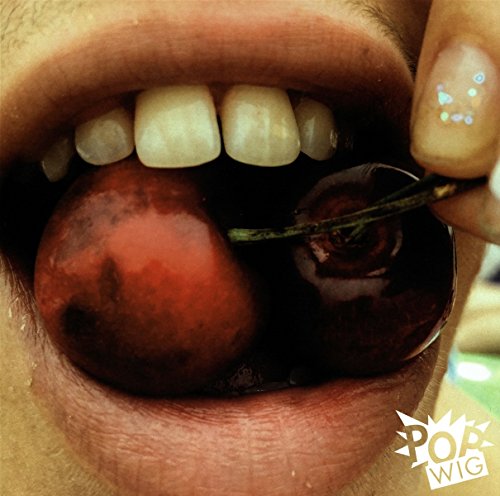 Close-up of lips holding two dark red cherries with a glitter nail.