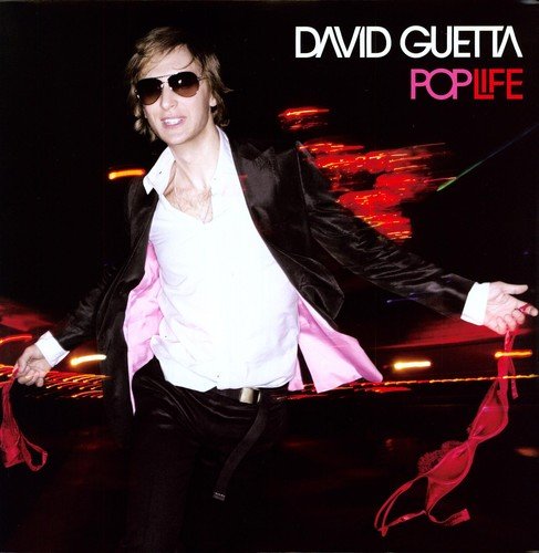 David Guetta wearing sunglasses and a suit, holding red lingerie against a dark background.
