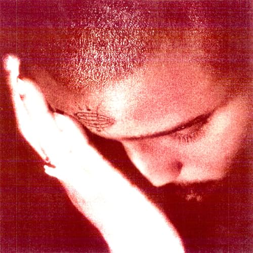Close-up of a person with eyes closed, hand touching their face.