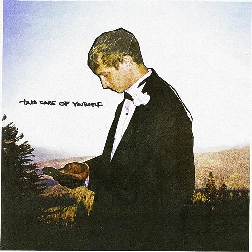 Album cover: man in tuxedo looking down at a phone in nature.