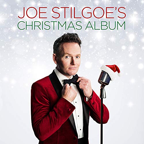 Joe Stilgoe in a red suit, smiling with a vintage microphone and Santa hat.