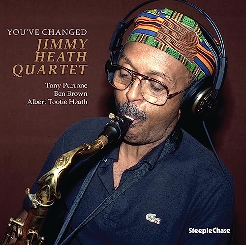 Jimmy Heath playing saxophone, wearing headphones and a patterned headband.