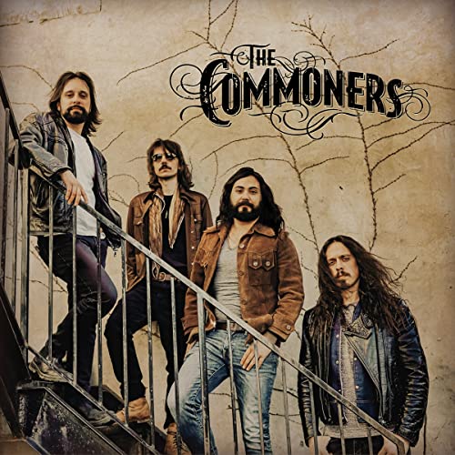 Four men posing on stairs with band name “The Commoners” above.