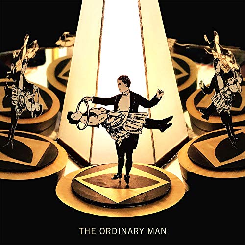 CD cover: man with hoop, performers in silhouette, geometric design.