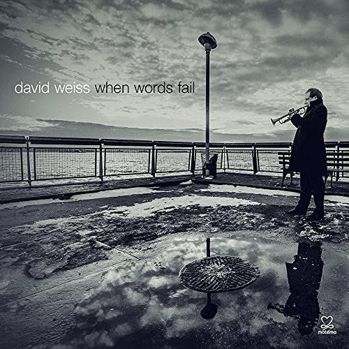 Black and white album cover featuring a man playing the trumpet by water.