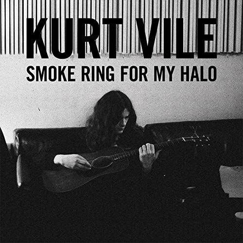 Kurt Vile album cover: a man with long hair playing acoustic guitar.