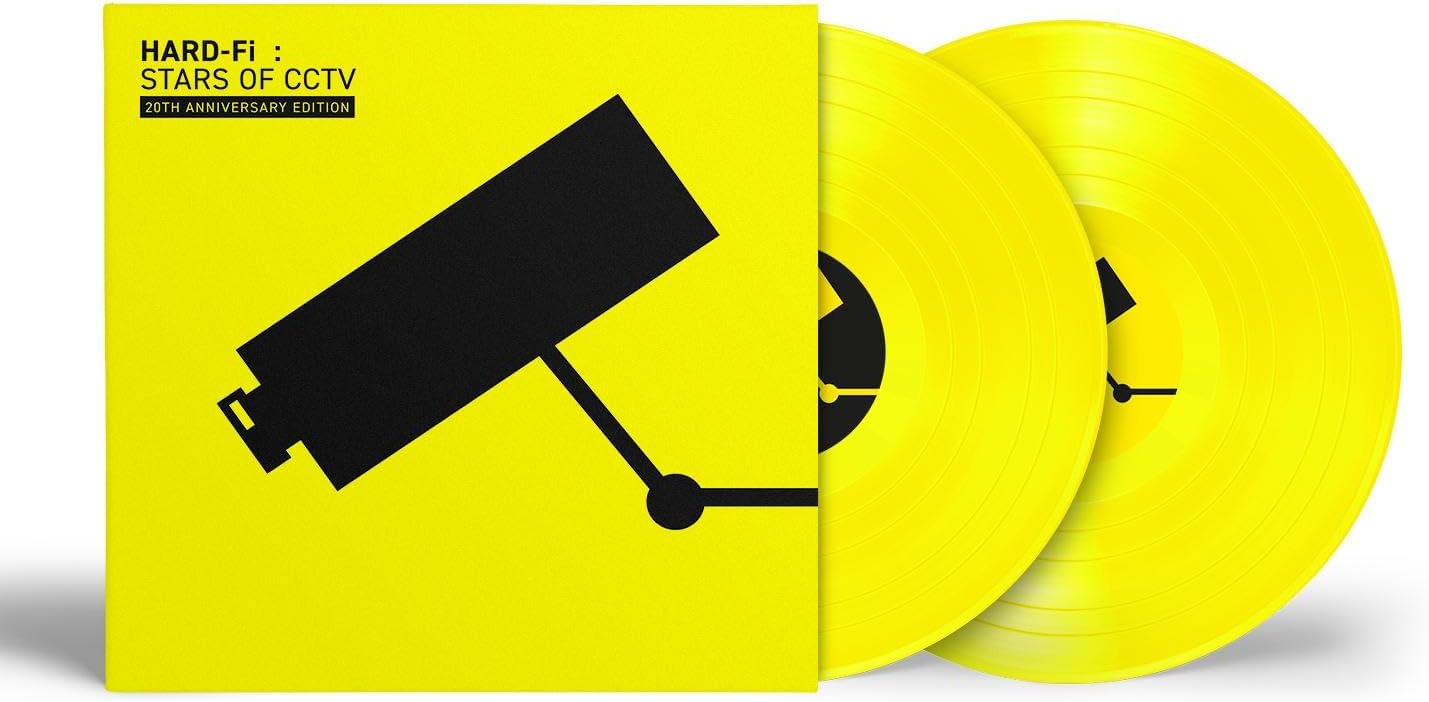 Yellow vinyl record with black security camera graphic, celebrating 20th anniversary.