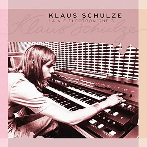 Album cover: Klaus Schulze at an electronic organ, pink background.