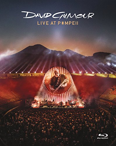 David Gilmour performing on stage at the Pompeii amphitheater before a large crowd.
