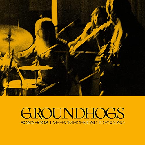 Black and yellow album cover featuring a band performing live on stage.