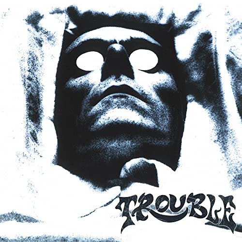 Dark, distorted face with glowing eyes and the band name "Trouble" below.