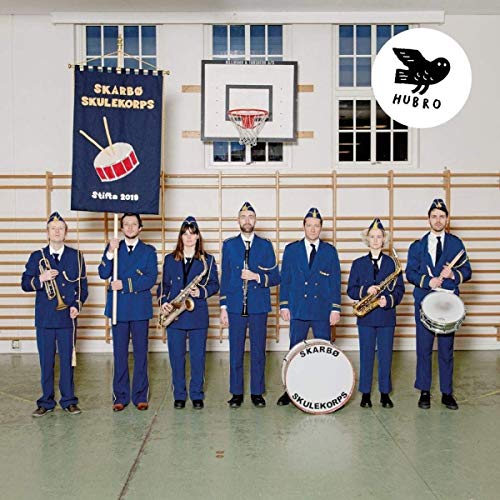 School band members in blue uniforms stand in a gymnasium.