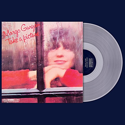 Album cover with a woman’s face reflected in a window, and a vinyl record.
