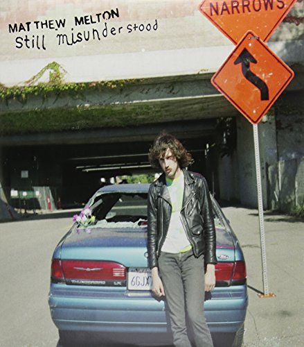 Album cover: man with car, road signs, and overgrown greenery.