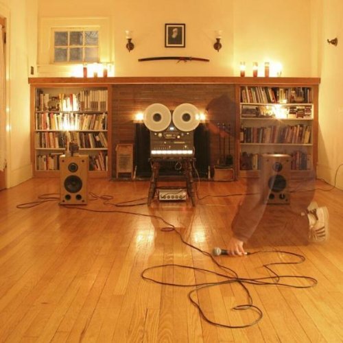 CDs and audio equipment in a warmly lit room with wooden floors.