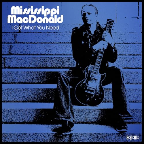 Mississippi Macdonald sits with a guitar on concrete steps, album cover.