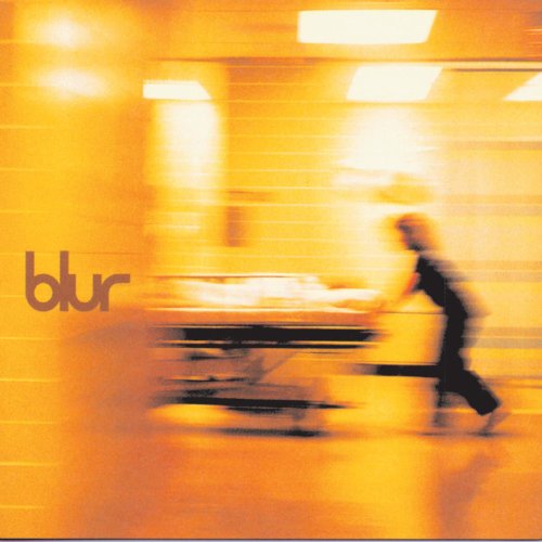 A blurry, golden-toned image of a person pushing a hospital gurney with the word blur.