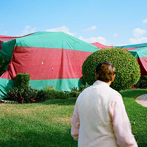 Vinyl record cover featuring a person looking at a green and red tent.