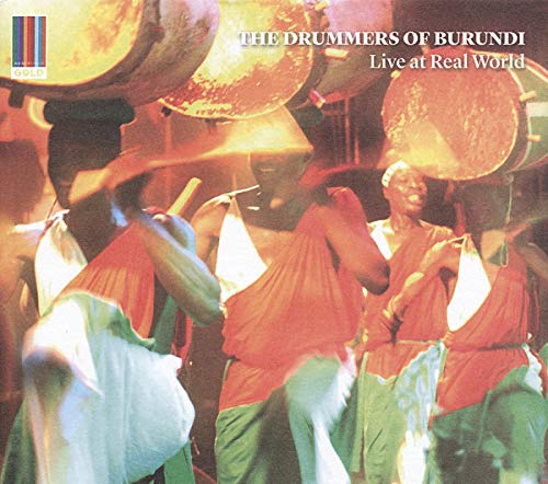 Burundi drummers in red robes playing large, traditional drums outdoors.