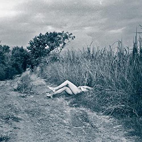 Black and white CD cover depicting a person lying in tall grass.