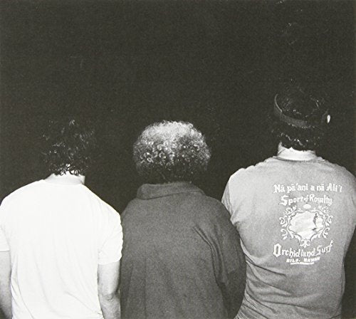Black and white photo of three people seen from behind.
