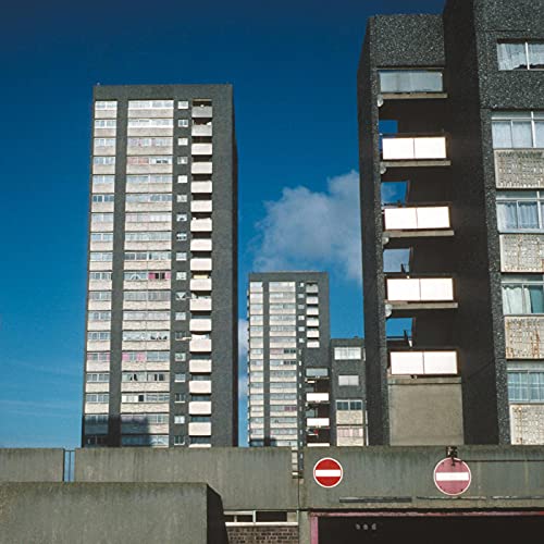 Brutalist concrete housing estate against a bright blue sky.