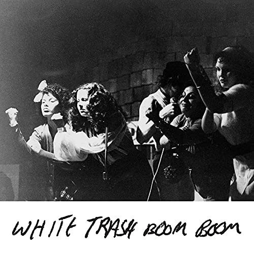 Black and white photo of a band performing with raised arms.