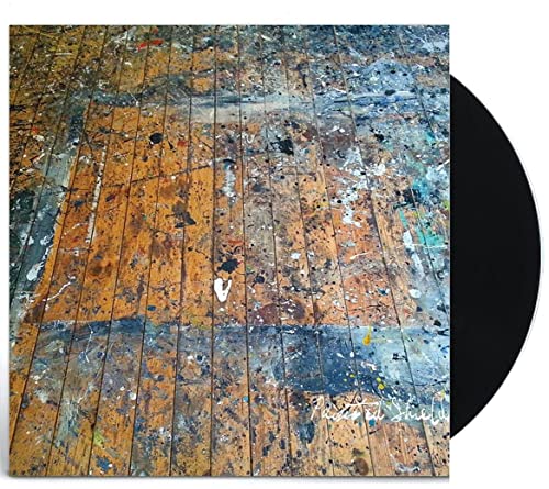 Vinyl record with cover art depicting a paint-splattered wooden floor.
