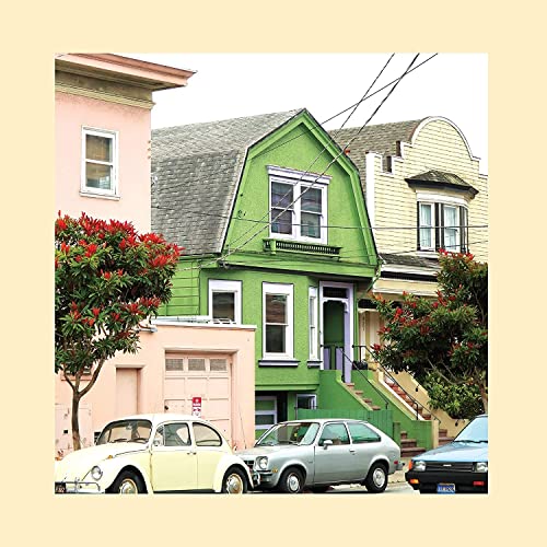 Colorful Victorian houses on a street with parked cars.
