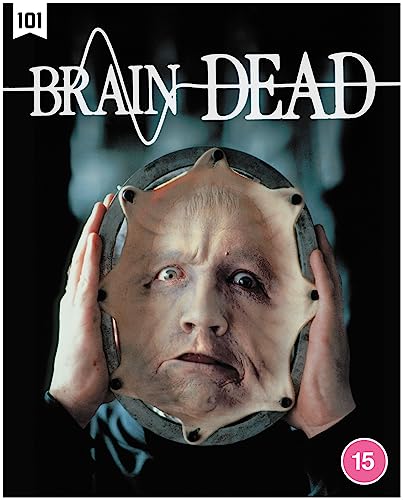 A person holds a circular frame containing a stretched human face against a dark background.