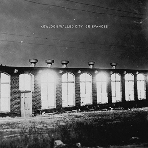Black and white album cover with a brick building and arched windows.