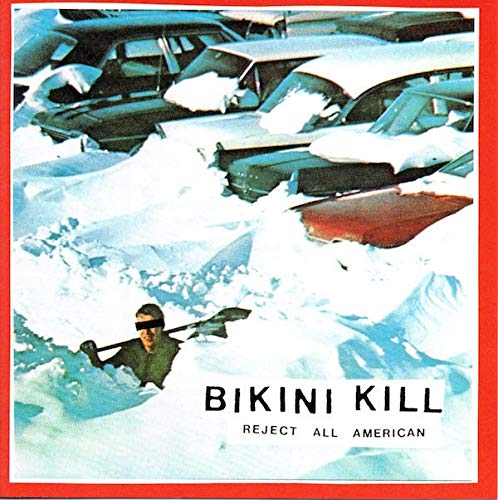 Bikini Kill album cover: crushed cars in snow, person with obscured face.