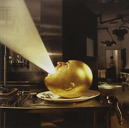 Golden baby head on a plate in a medical setting.