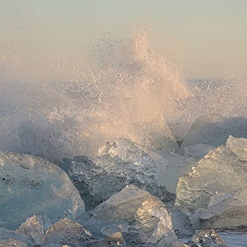 Ocean waves crashing against icy rocks in muted, pastel tones.