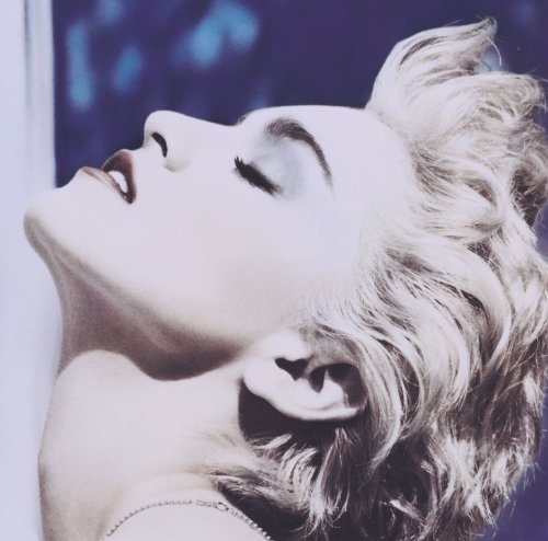 Close-up of Madonna with blonde curly hair, eyes closed, looking upwards.