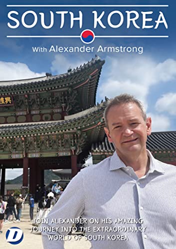 Alexander Armstrong stands in front of a traditional South Korean palace building.