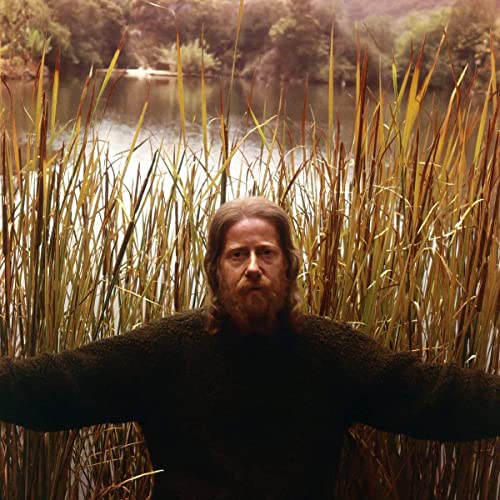 Portrait of Eden Ahbez, a man with long hair and a beard, in reeds.