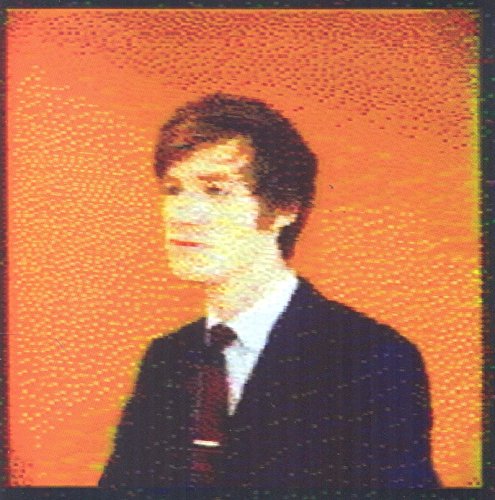 Portrait of a man with brown hair against a textured orange background.