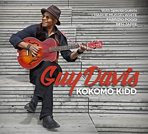 Guy Davis sits playing an acoustic guitar, album cover for “Kokomo Kidd.”