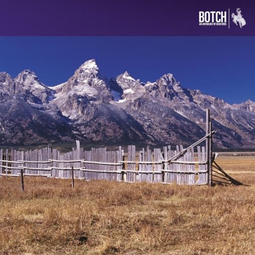 Mountain landscape with a weathered wooden fence in a field.