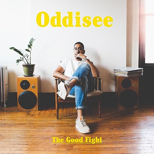 Oddisee album cover: man seated with speakers, plant, and books.