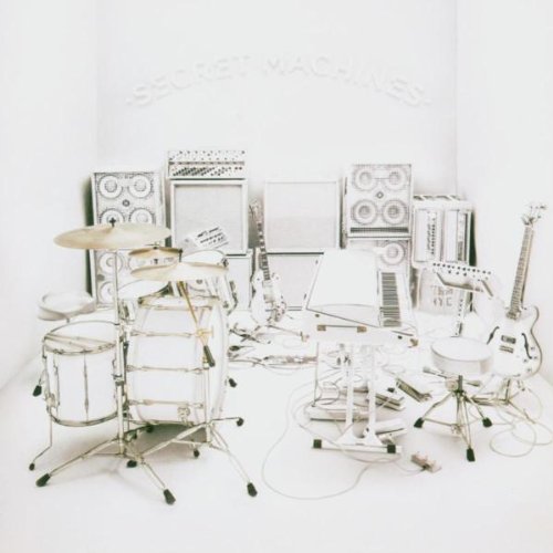 All-white musical instruments and equipment arranged in a minimalist setting.