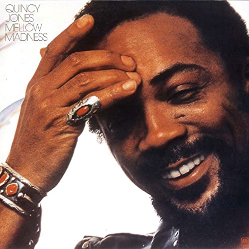 Quincy Jones album cover, close-up of smiling man with hand raised.