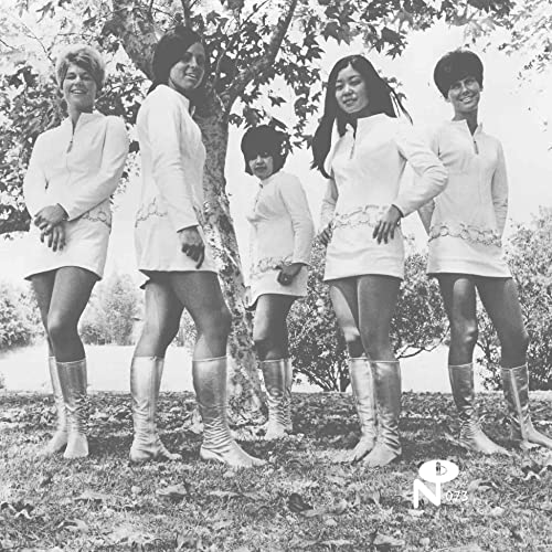 Black and white photo of four women in white dresses and boots.