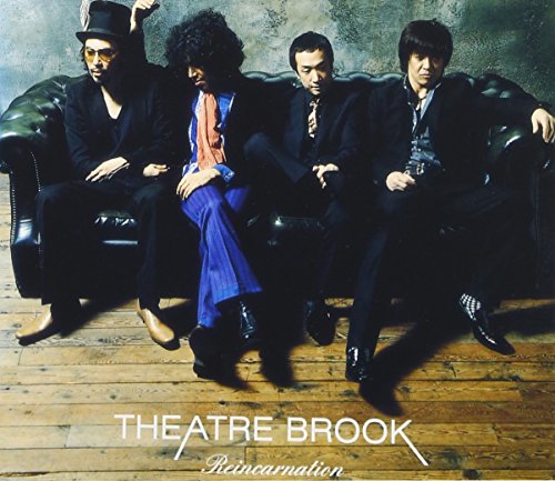 Four men in suits sit on a leather couch, album cover for “Reincarnation.”